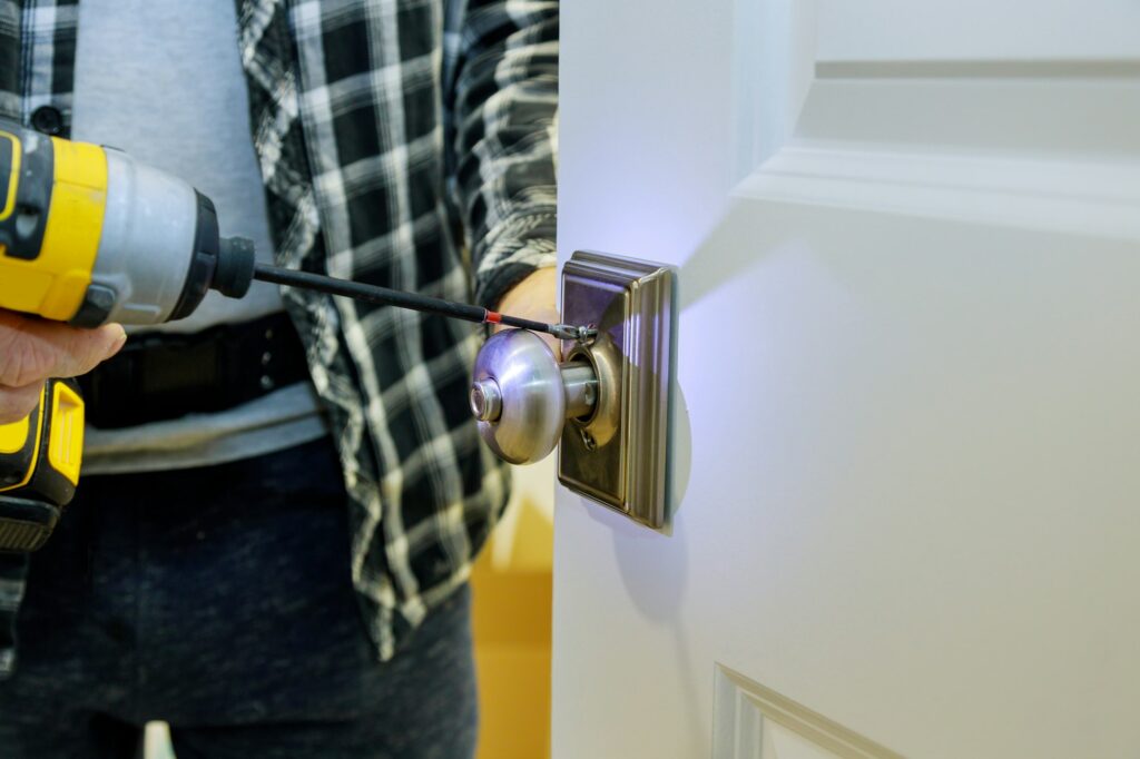 Handyman installing the door lock in the worker's hands new door locker