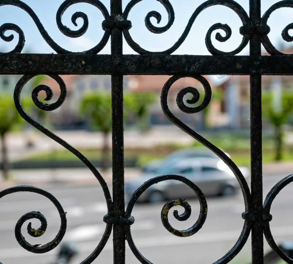 Detail of a wrought iron fence on a street in the city. Selective focus.